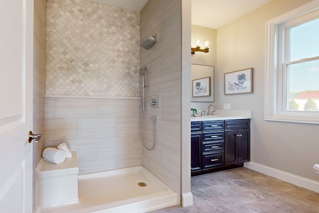 bathroom with vanity, a tile shower, and toilet