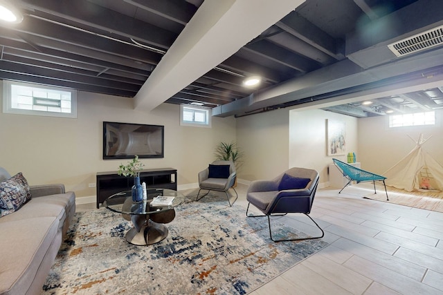 living room featuring light hardwood / wood-style flooring, beam ceiling, and a healthy amount of sunlight