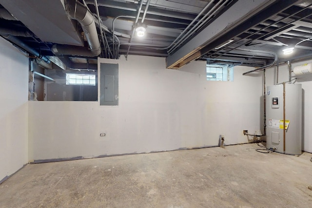 basement with plenty of natural light, water heater, and electric panel