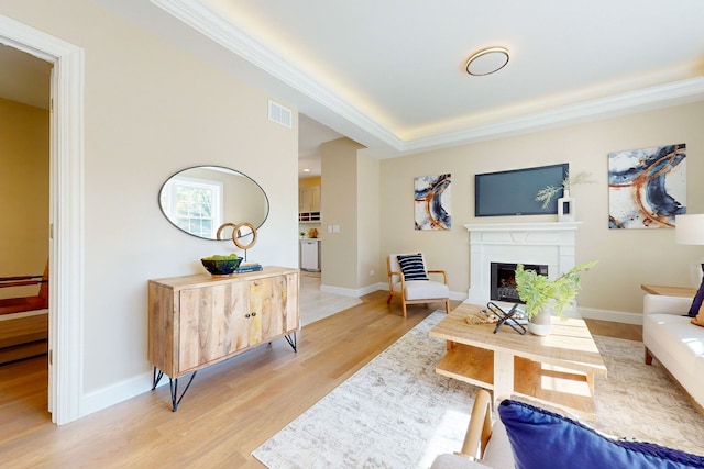 living room featuring ornamental molding and light hardwood / wood-style flooring