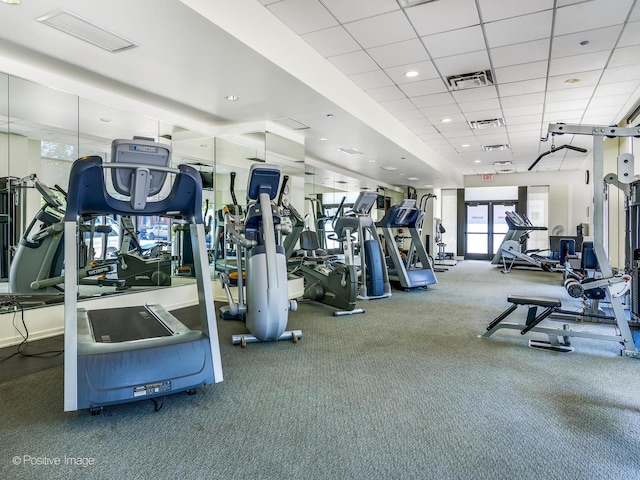 workout area featuring a paneled ceiling and carpet floors