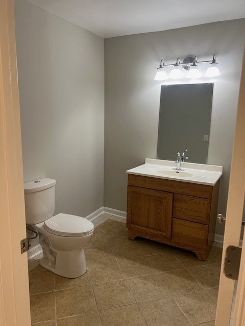 bathroom featuring tile patterned flooring, vanity, and toilet