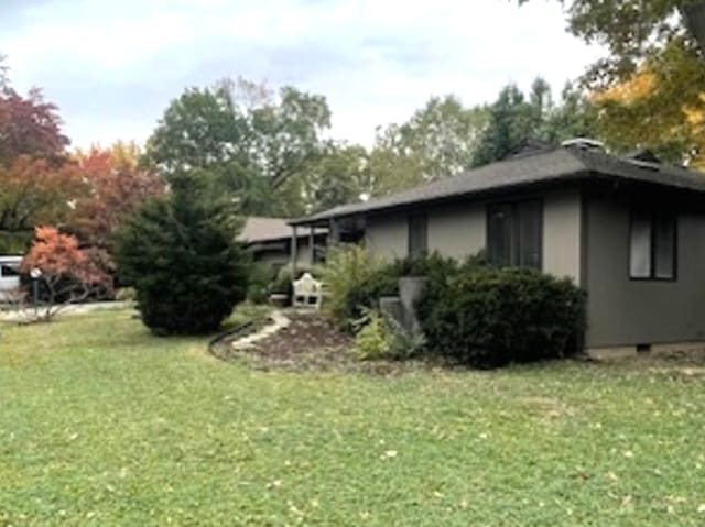 view of side of home with a lawn