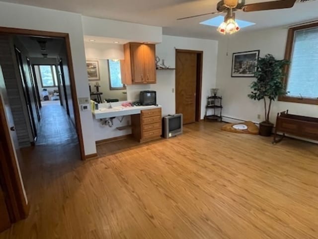 kitchen featuring light hardwood / wood-style flooring, kitchen peninsula, and ceiling fan