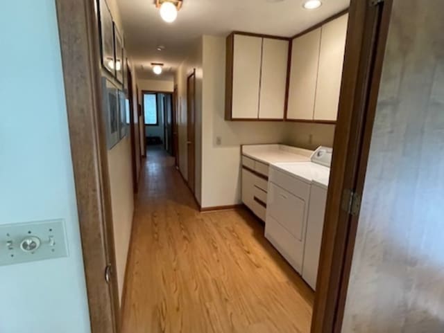 laundry area featuring light hardwood / wood-style floors and washer and clothes dryer