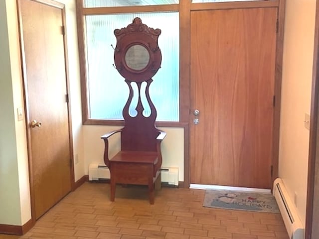 entrance foyer featuring a baseboard heating unit and light wood-type flooring