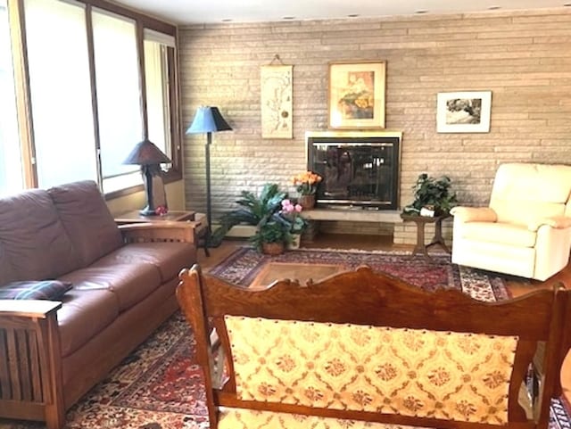 living room featuring brick wall and a wall of windows