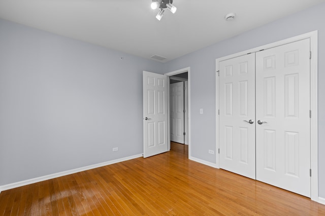 unfurnished bedroom featuring a closet and light hardwood / wood-style floors