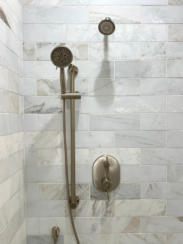 interior details featuring tiled shower