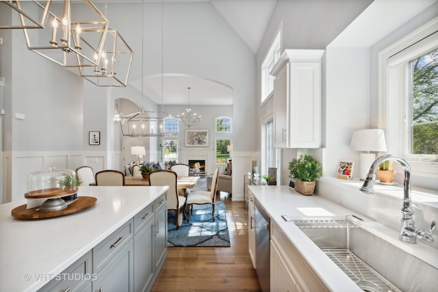 kitchen featuring dark wood-type flooring, white cabinetry, sink, and pendant lighting