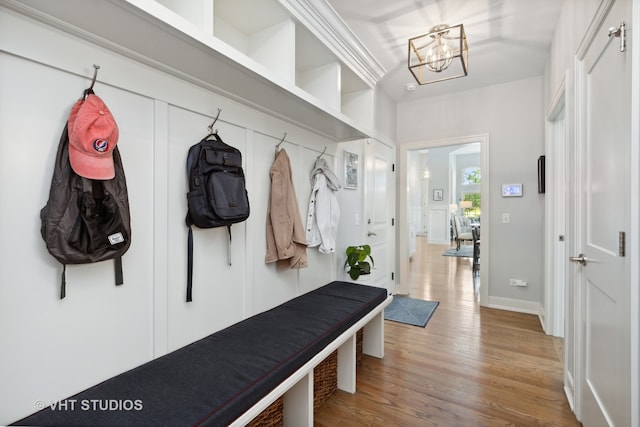 mudroom featuring light wood-type flooring and an inviting chandelier