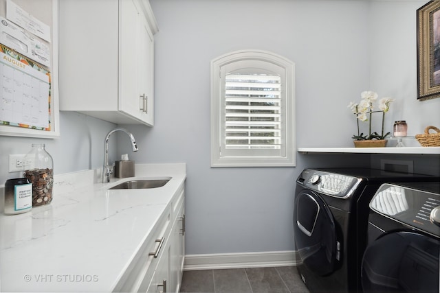 clothes washing area featuring cabinets, sink, and independent washer and dryer