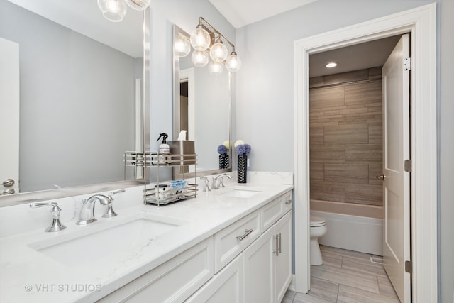 full bathroom with toilet, tiled shower / bath combo, and vanity