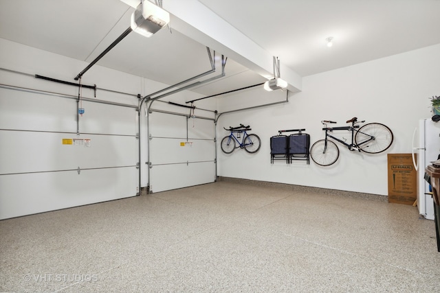 garage with a garage door opener and white refrigerator