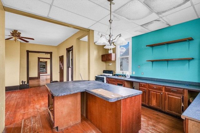 kitchen with pendant lighting, a drop ceiling, a center island, and white gas range oven