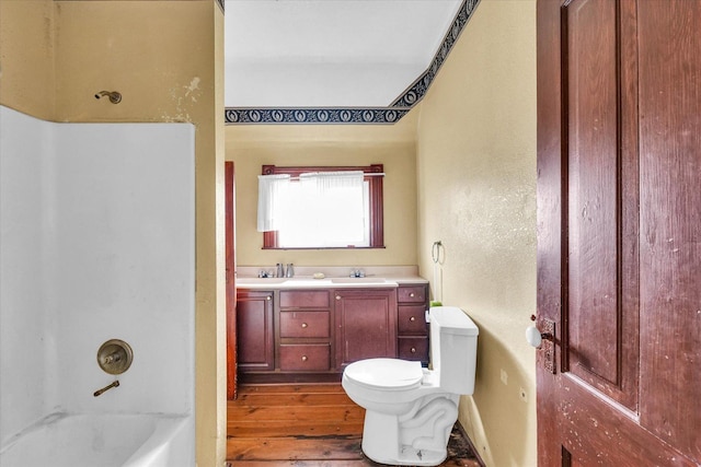 full bathroom featuring shower / bath combination, vanity, wood-type flooring, and toilet