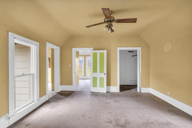 carpeted empty room featuring vaulted ceiling and ceiling fan