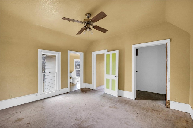 unfurnished bedroom featuring connected bathroom, light colored carpet, ceiling fan, and lofted ceiling