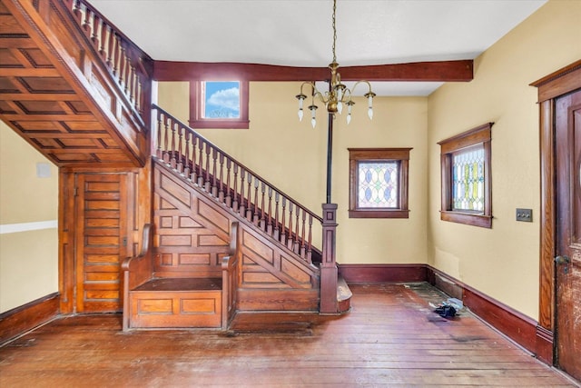 staircase featuring hardwood / wood-style flooring and an inviting chandelier