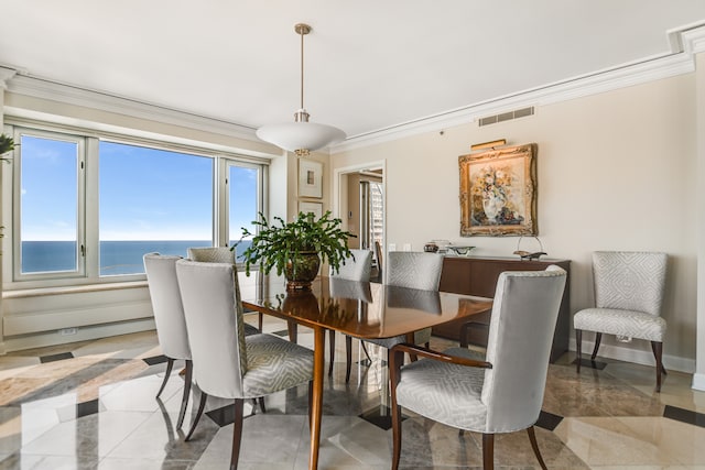 dining space with ornamental molding and a water view