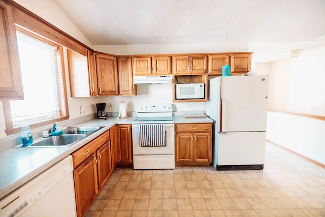 kitchen with vaulted ceiling, white appliances, and sink