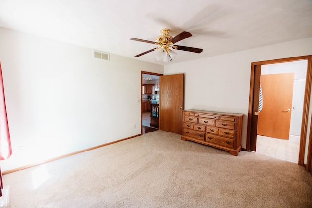 unfurnished bedroom with light colored carpet and ceiling fan