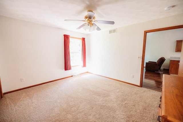 carpeted empty room featuring ceiling fan