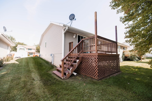 back of property featuring a lawn and a deck