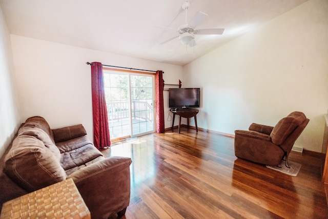 living room featuring ceiling fan, hardwood / wood-style floors, and vaulted ceiling