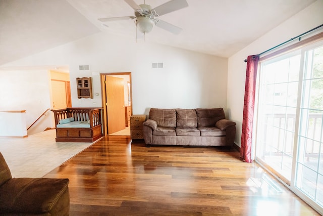 living room featuring ceiling fan, wood-type flooring, and vaulted ceiling