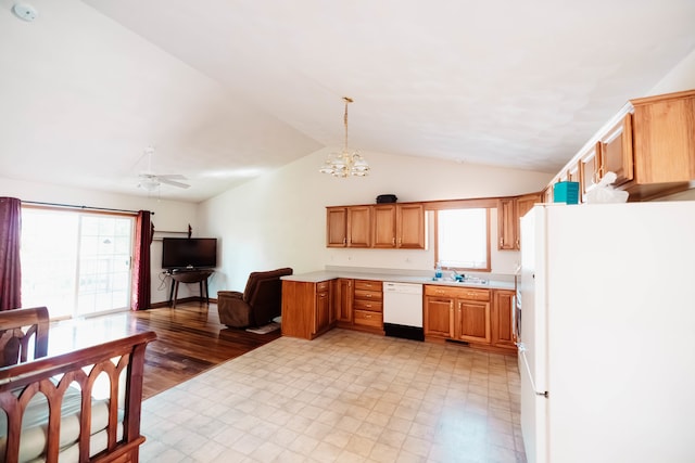 kitchen featuring ceiling fan with notable chandelier, white appliances, vaulted ceiling, and a healthy amount of sunlight