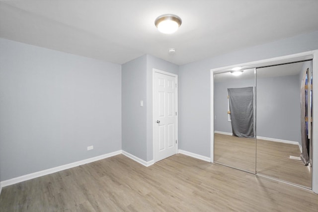 unfurnished bedroom featuring wood finished floors and a closet