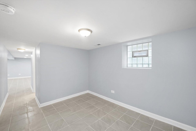 basement with baseboards and tile patterned flooring