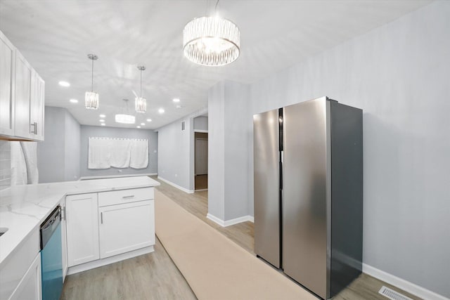 kitchen with freestanding refrigerator, dishwashing machine, white cabinets, light stone countertops, and recessed lighting