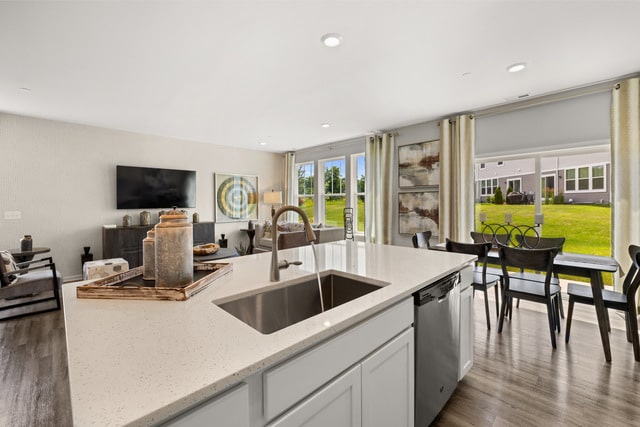 kitchen featuring white cabinetry, stainless steel dishwasher, light stone countertops, and light hardwood / wood-style floors