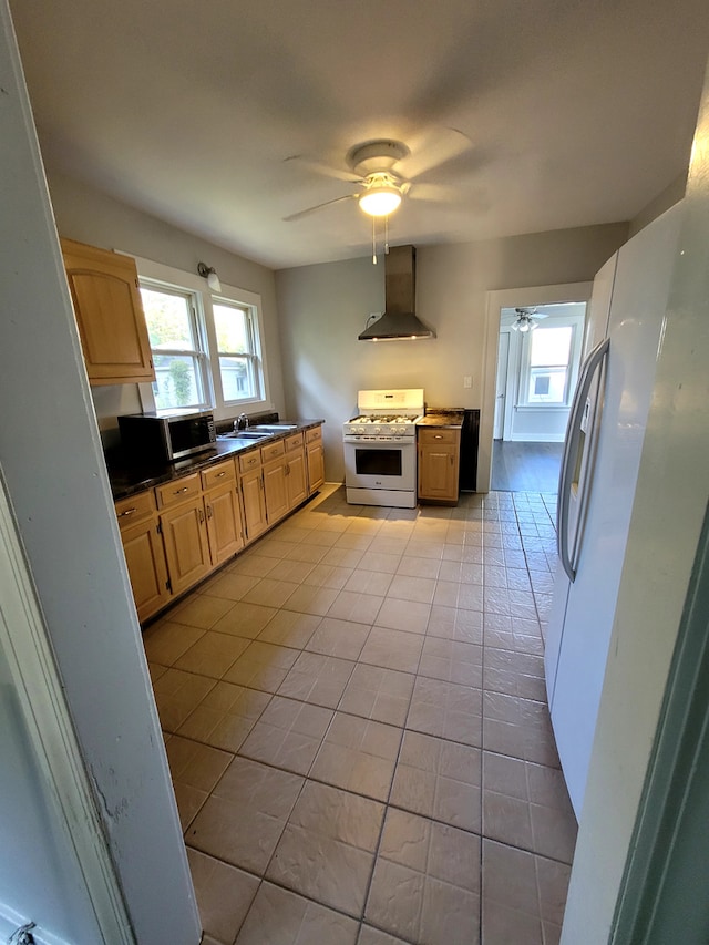 kitchen featuring wall chimney exhaust hood, white appliances, light tile patterned floors, and ceiling fan