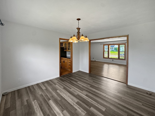 empty room featuring dark hardwood / wood-style floors and a chandelier