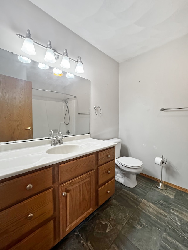 bathroom with vanity, toilet, and a shower