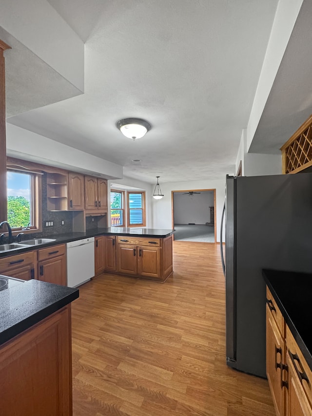 kitchen featuring black refrigerator, plenty of natural light, dishwasher, and sink