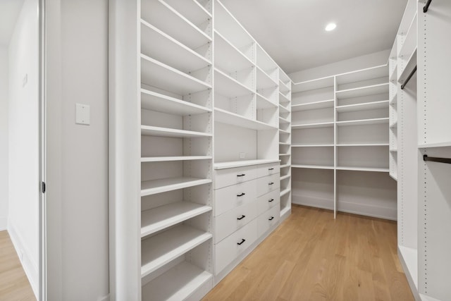 walk in closet with light hardwood / wood-style flooring