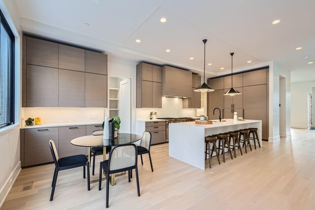 unfurnished living room featuring sink and light hardwood / wood-style flooring