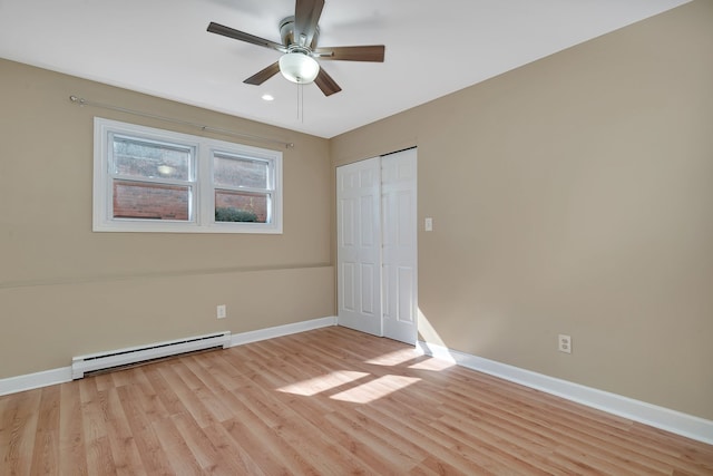 spare room with a baseboard radiator, ceiling fan, and light hardwood / wood-style floors