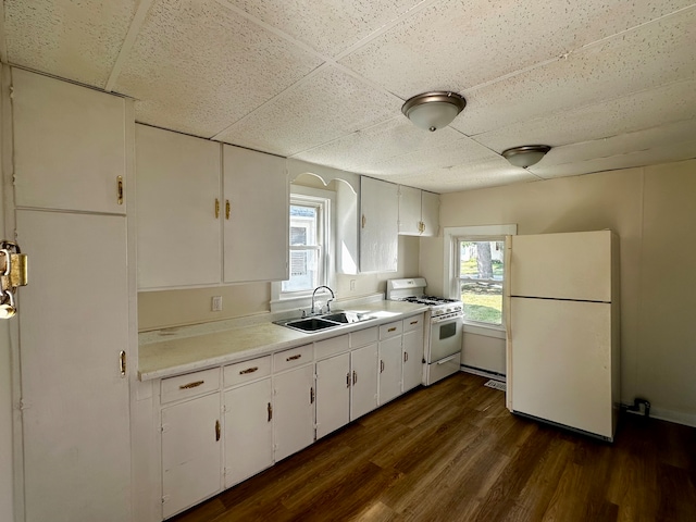 kitchen featuring plenty of natural light, white appliances, white cabinetry, and sink