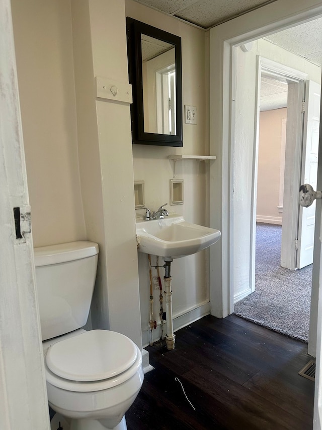 bathroom with hardwood / wood-style floors and toilet