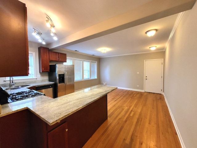 kitchen featuring crown molding, appliances with stainless steel finishes, light stone countertops, light hardwood / wood-style floors, and sink