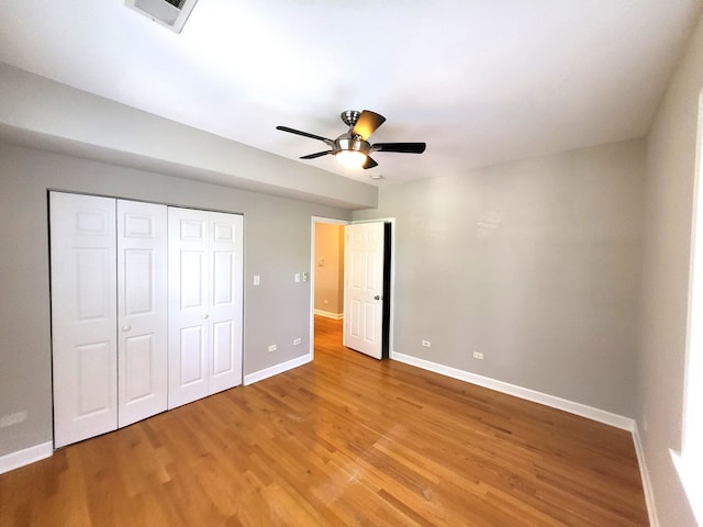 unfurnished bedroom with ceiling fan, a closet, and light hardwood / wood-style floors