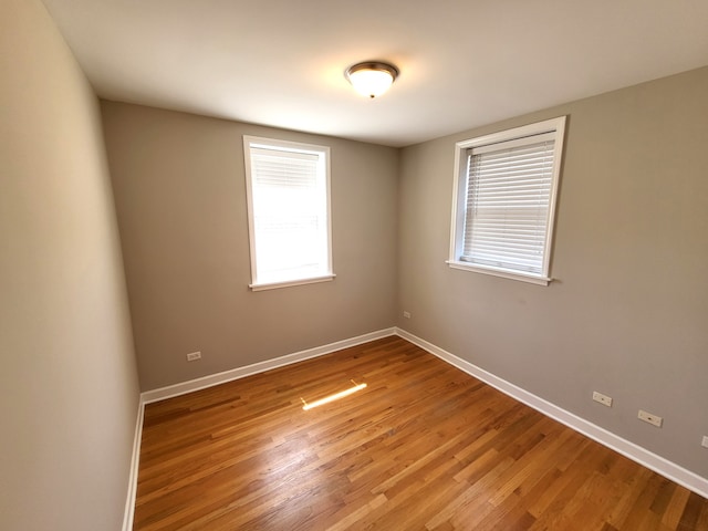 unfurnished room with hardwood / wood-style flooring and a healthy amount of sunlight