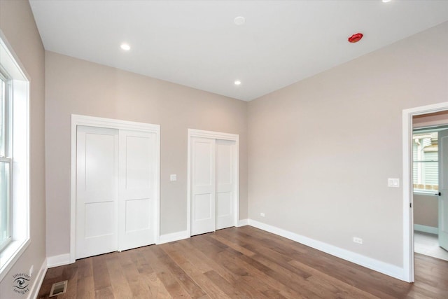 135 W 18th St, Lockport, IL 60441 - unfurnished bedroom featuring two closets, wood finished floors, baseboards, and recessed lighting