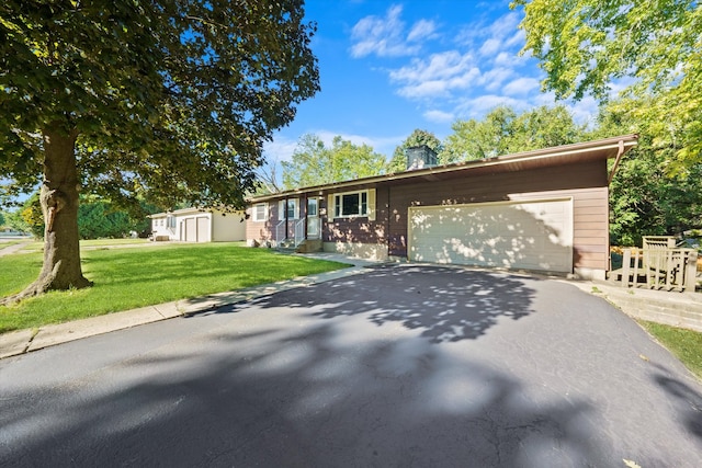 ranch-style house featuring a garage and a front lawn