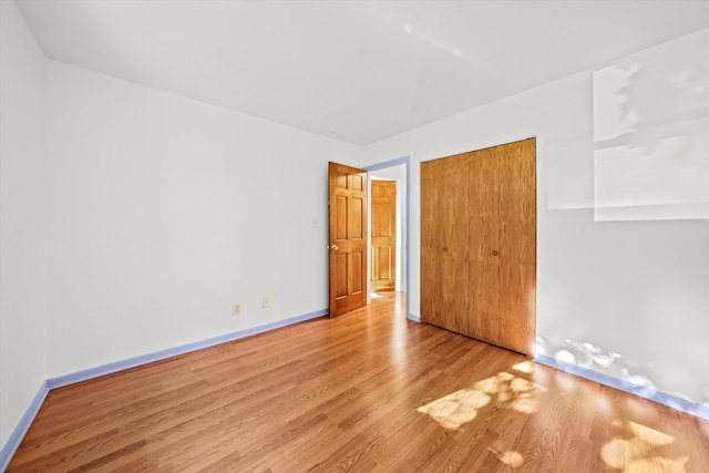 unfurnished bedroom featuring light wood-type flooring and a closet